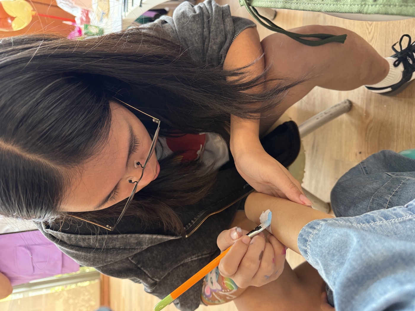 Youth volunteer face-painting a child